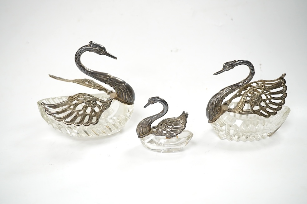 A graduated set of three silver mounted glass swan condiments, London, 1978, largest height 12.9cm. Condition - fair